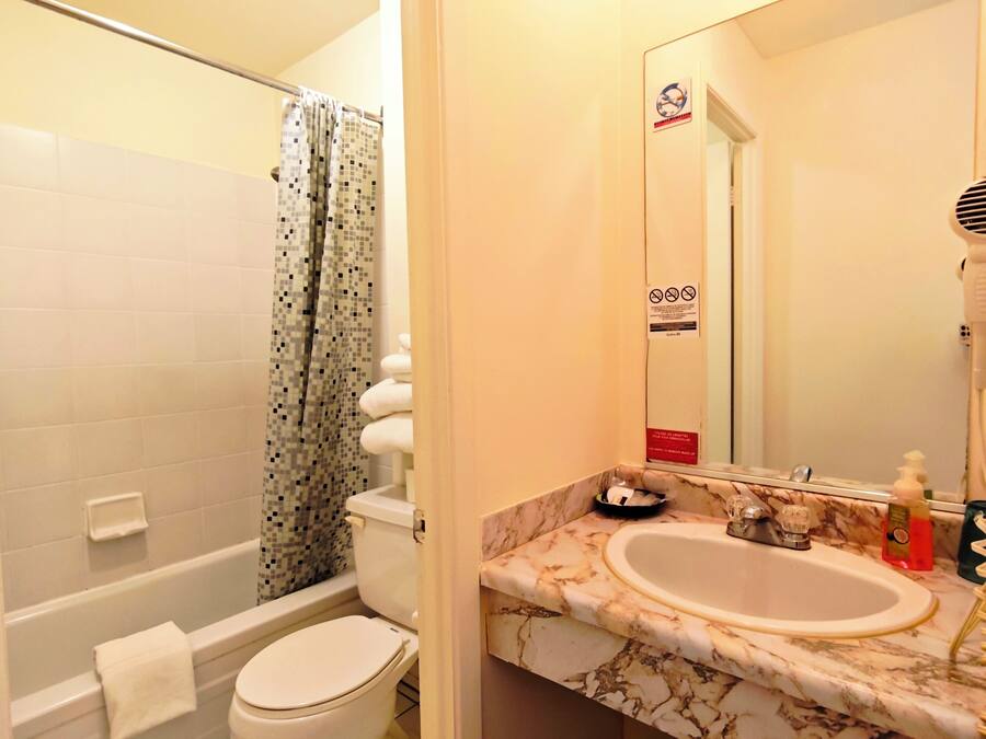 A bathroom with a toilet, sink, and shower.
