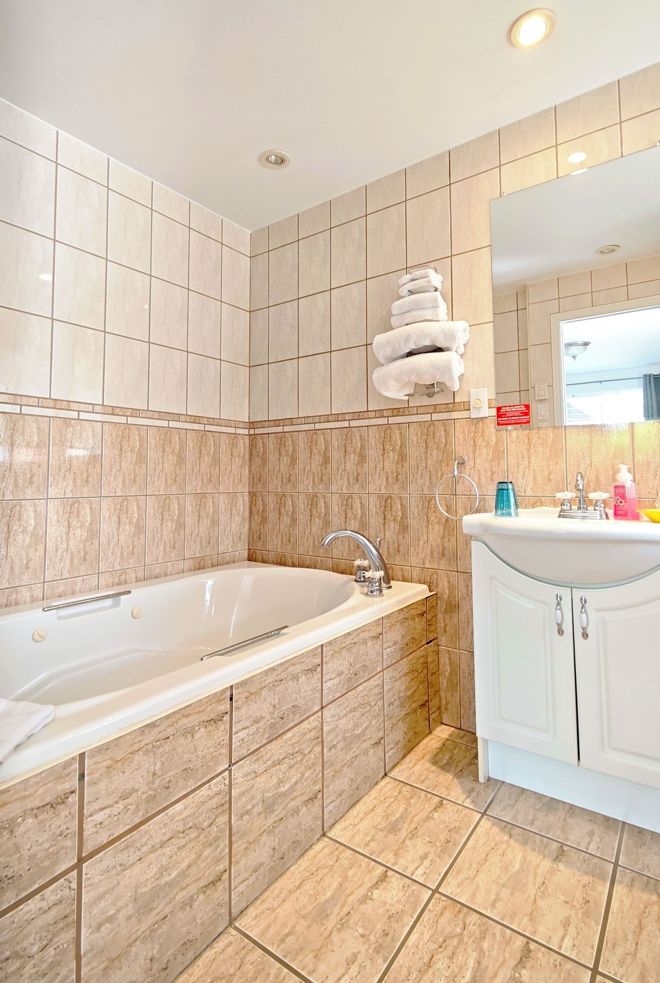 Une salle de bain avec une baignoire, un lavabo et des murs carrelés.