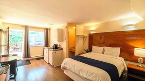 A hotel room with a bed, desk, and a view of the outdoors. - Motel des Pentes et Suites (Saint-Sauveur)