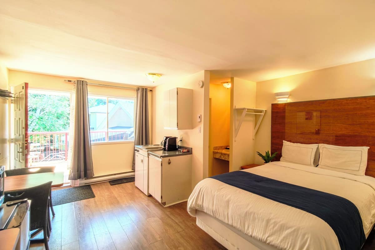 Une chambre d’hôtel avec un lit, un bureau et une vue sur l’extérieur.