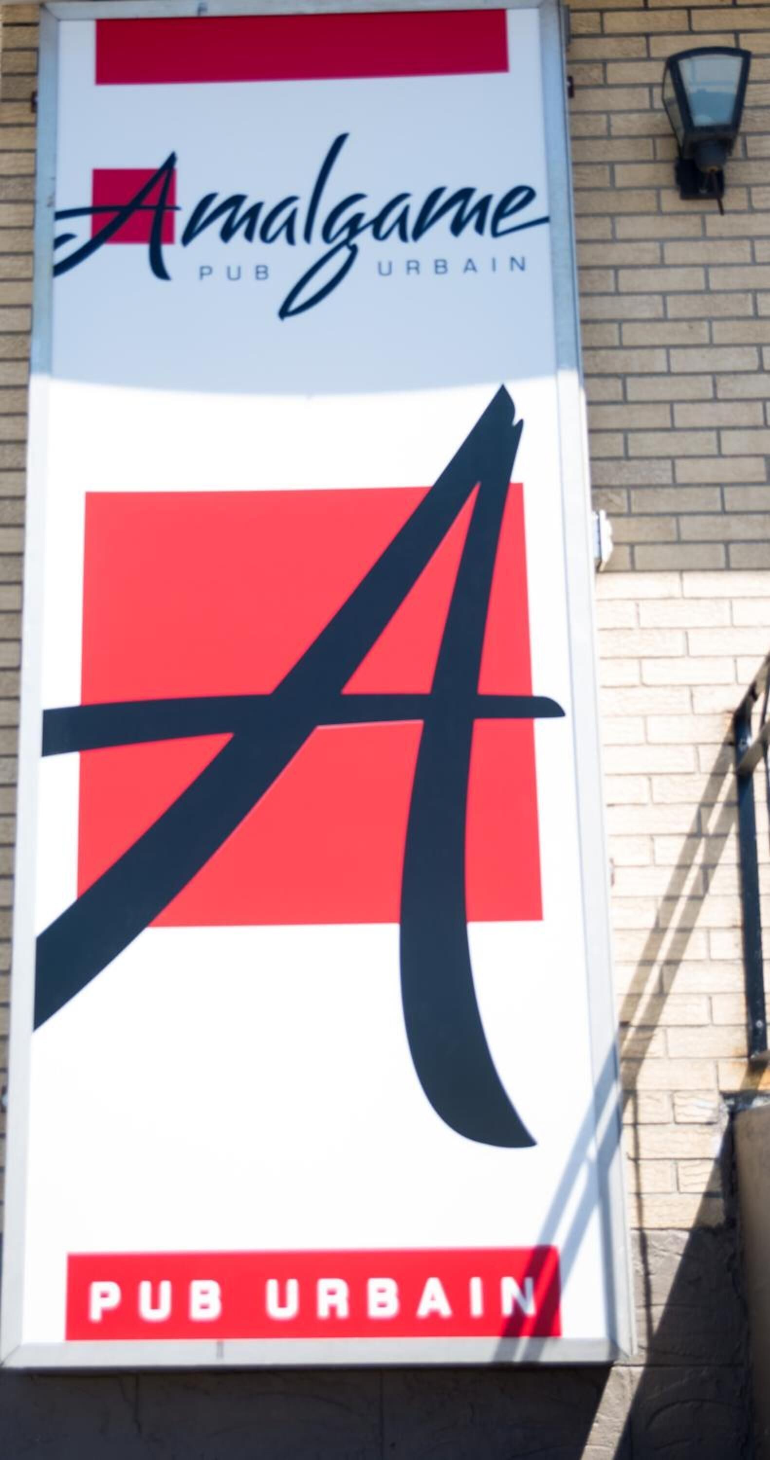 A vertical sign for 'Amalgame Pub Urban' with a large stylized 'A' logo, a red and white color scheme, and the words 'PUB URBAN' at the bottom.