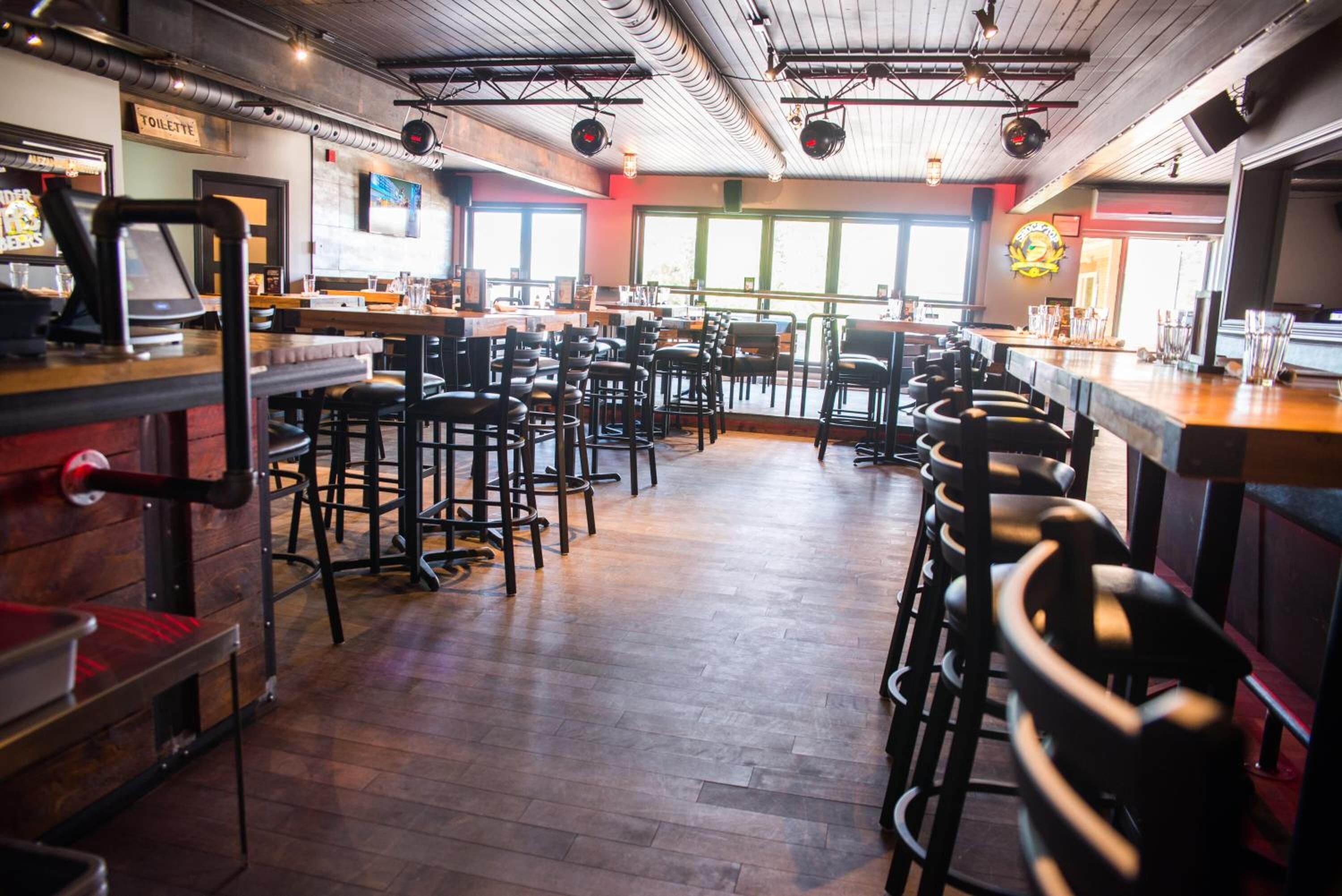 A restaurant with multiple bar seating and a visible restroom sign.