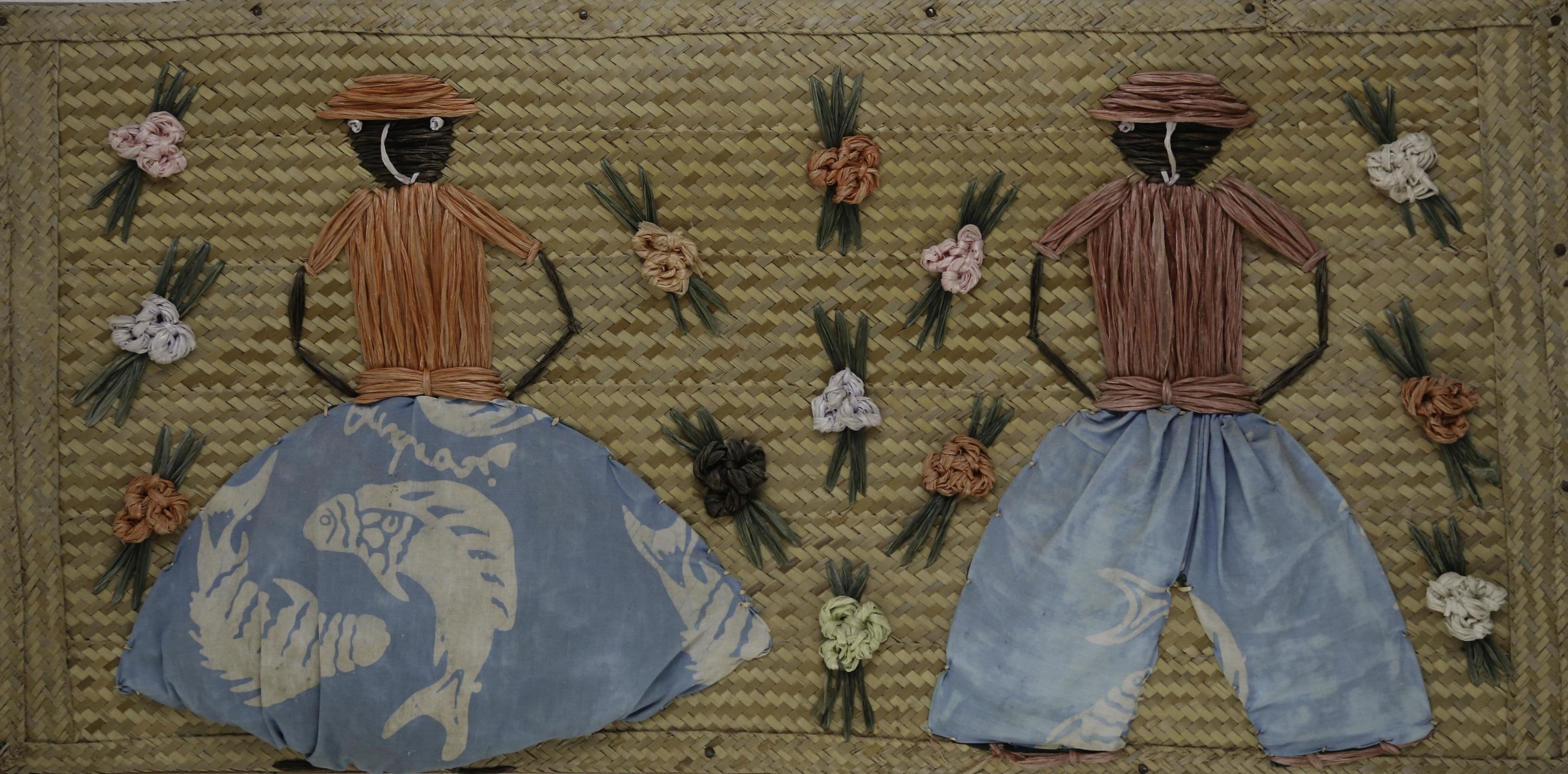 Dos figuras de paja sobre un fondo tejido.