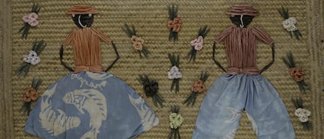 Two figures made of straw on a woven background.