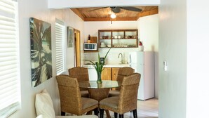 A compact living space with a dining area, kitchenette, and a sofa. - Tingum Village Hotel (Dunmore Town)