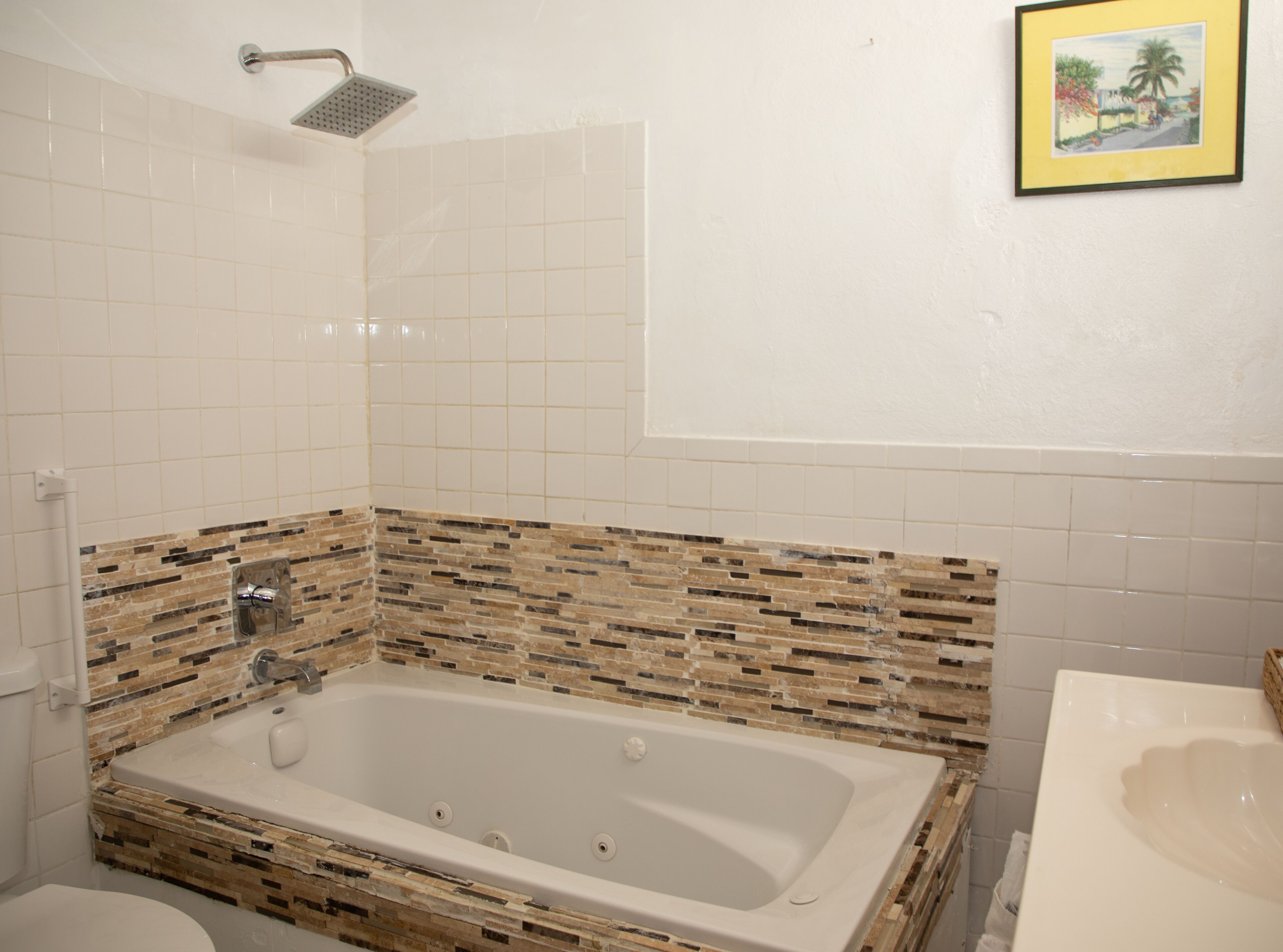 A bathroom with a large bathtub, a shower, and a sink.