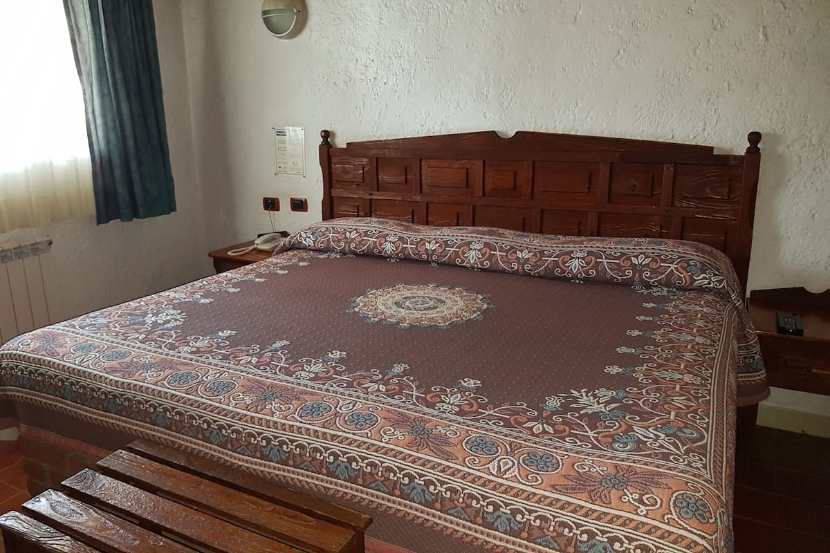 Escritorio, cortinas blackout y tabla de planchar con plancha