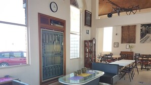 A dining area with a large table and chairs, a vintage clawfoot bathtub, and a wooden cabinet.