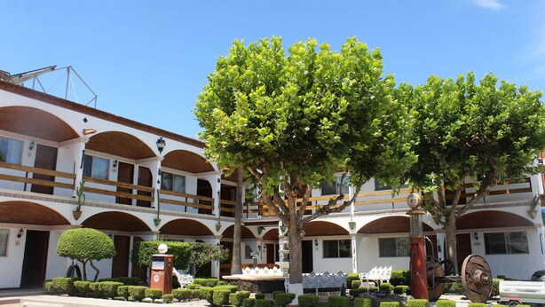 A hotel with a courtyard, multiple balconies, and a fountain.