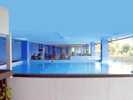 Una piscina techada, sillones reclinables de piscina