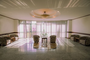 A spacious lobby with a polished floor, a central table, and zebra-striped chairs arranged around it. - City Bay Hotel (Hon Gai)
