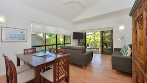 A spacious living area with a dining table, sofas, and a TV. - Driftwood Mantaray (Port Douglas)