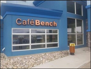 A building with a sign reading "Café Bench" above a window.