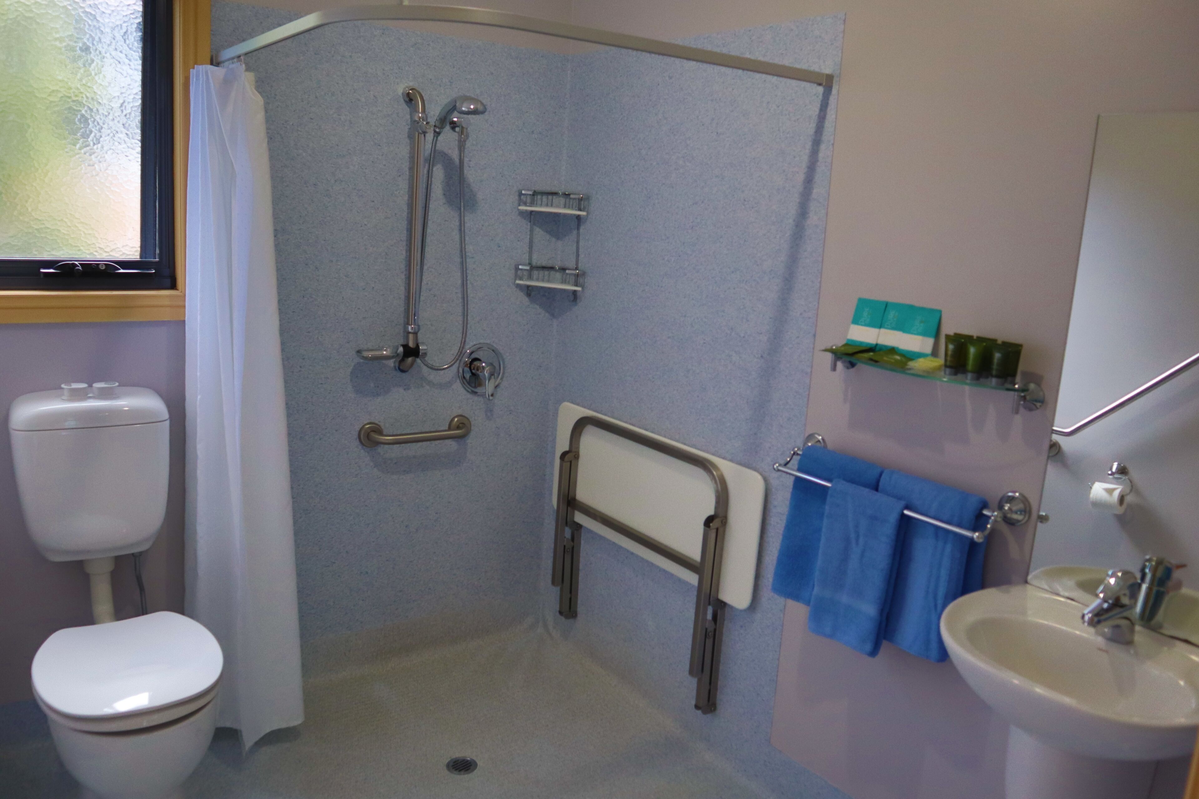A bathroom with a shower, toilet, and sink.
