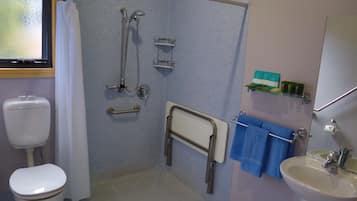 A bathroom with a shower, toilet, and sink.