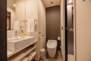 A modern bathroom with a white sink, mirror, and towel rack.