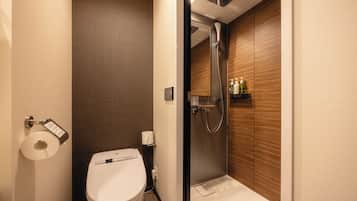 A modern bathroom with a toilet, a shower, and a wooden wall.