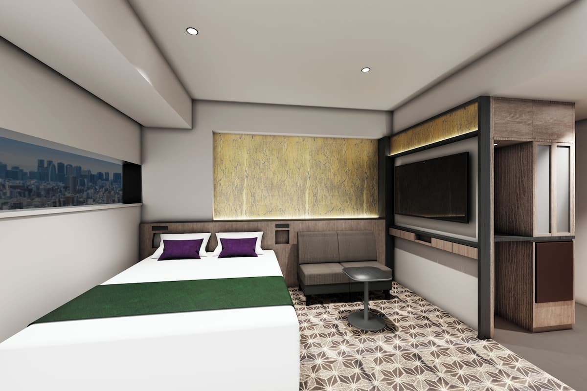 A modern hotel room with a bed, seating area, TV, and a cityscape view.