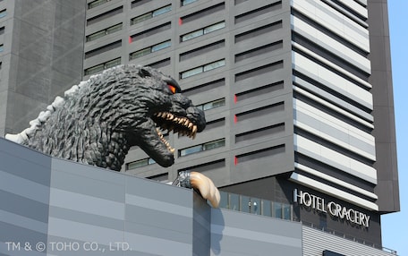 A building with a large, lifelike dinosaur sculpture on the facade.