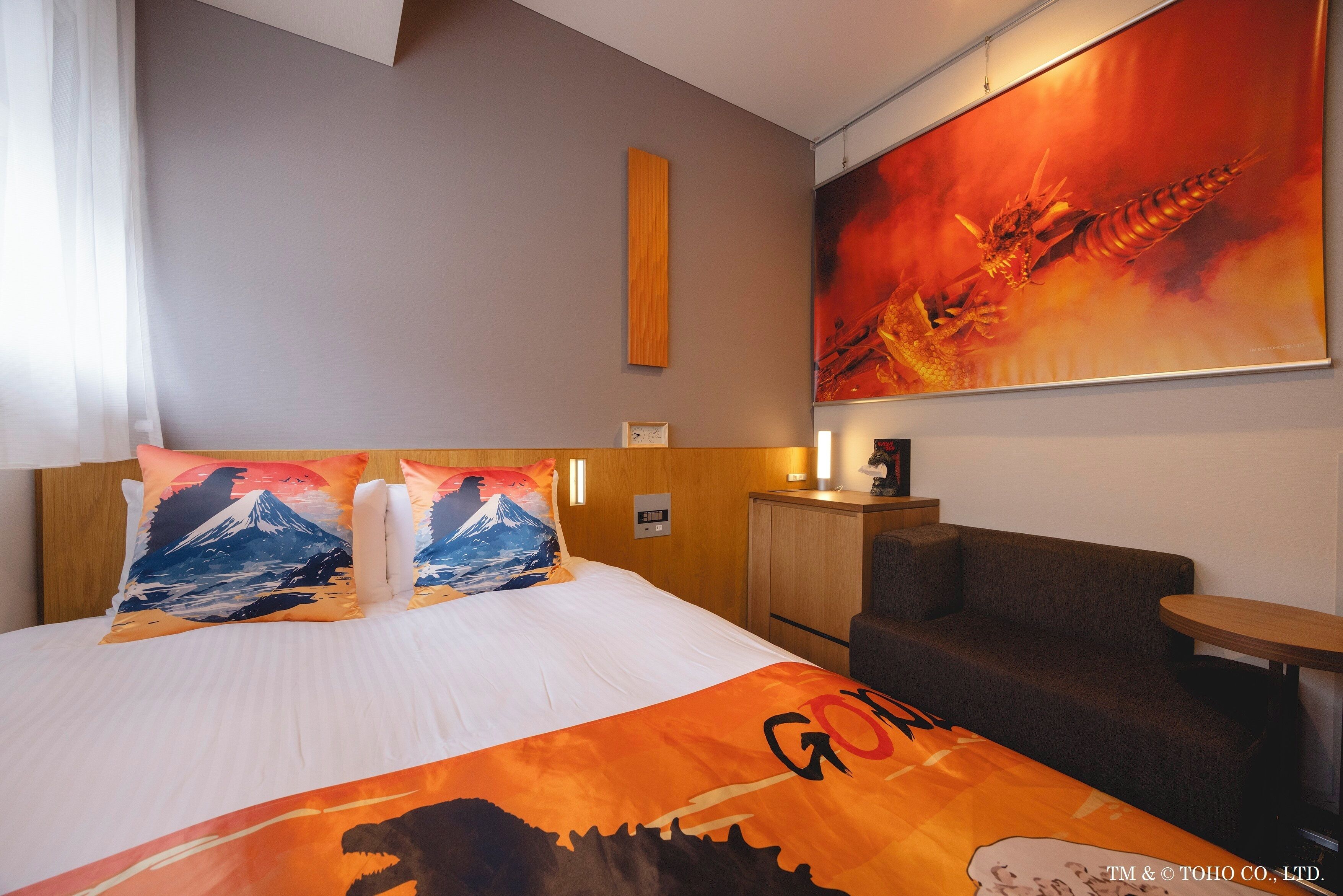 Una habitación de hotel con una cama, una mesita de noche, una silla y un cuadro grande en la pared.