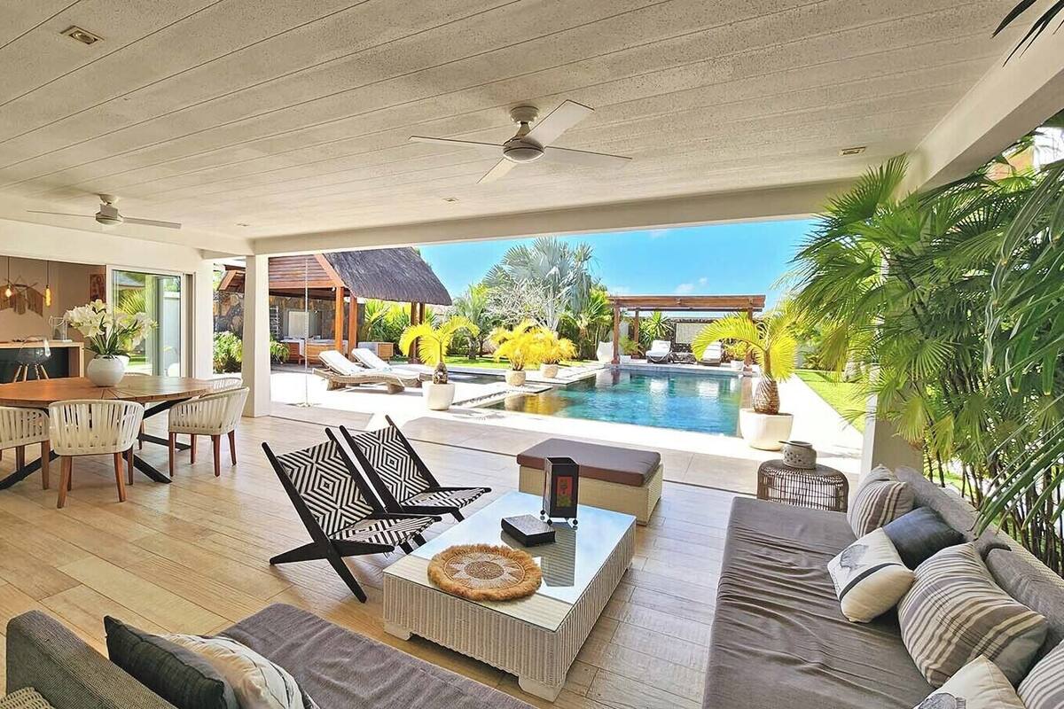 Ein großzügiger Wohnbereich mit Pool, modernen Möbeln und Blick auf den Pool.