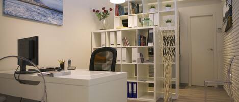 Un bureau moderne comprenant un bureau, une chaise, une bibliothèque et des objets de décoration.
