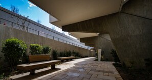 An outdoor area with benches, a concrete wall, and a pathway. - Elma Hotel and Art Complex (Zikhron Ya'aqov)