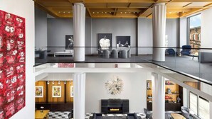 A spacious lobby with a checkered floor, a fireplace, and a seating area with sofas and a coffee table. - Le Méridien Columbus, The Joseph (Columbus)