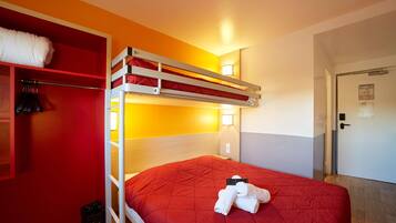 Camera con letto a castello, copriletto rosso, armadio con abiti appesi e porta con un avviso.