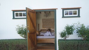 Un dormitorio con una puerta de madera, una cama y un cuadro en la pared.