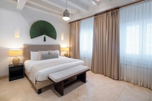 A modern bedroom with a large bed, bedside lamps, a ceiling fan, and sheer curtains. - Casa La Cartujita (Cartagena)