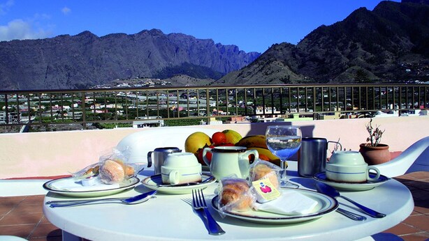 Mesa lista para el desayuno con vistas a la montaña.