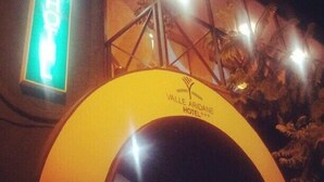 Exterior del Hotel Valle Aridane, con un arco destacado y una luminosa señal de neón.