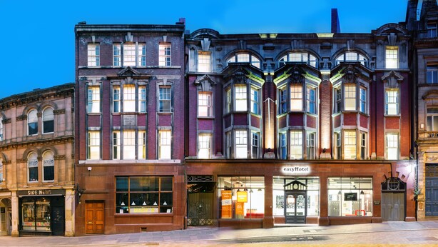 Um edifício histórico com fachada comercial no andar térreo com a inscrição 