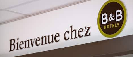 A sign with "Bienvenue chez B&B Hotels" and a logo.
