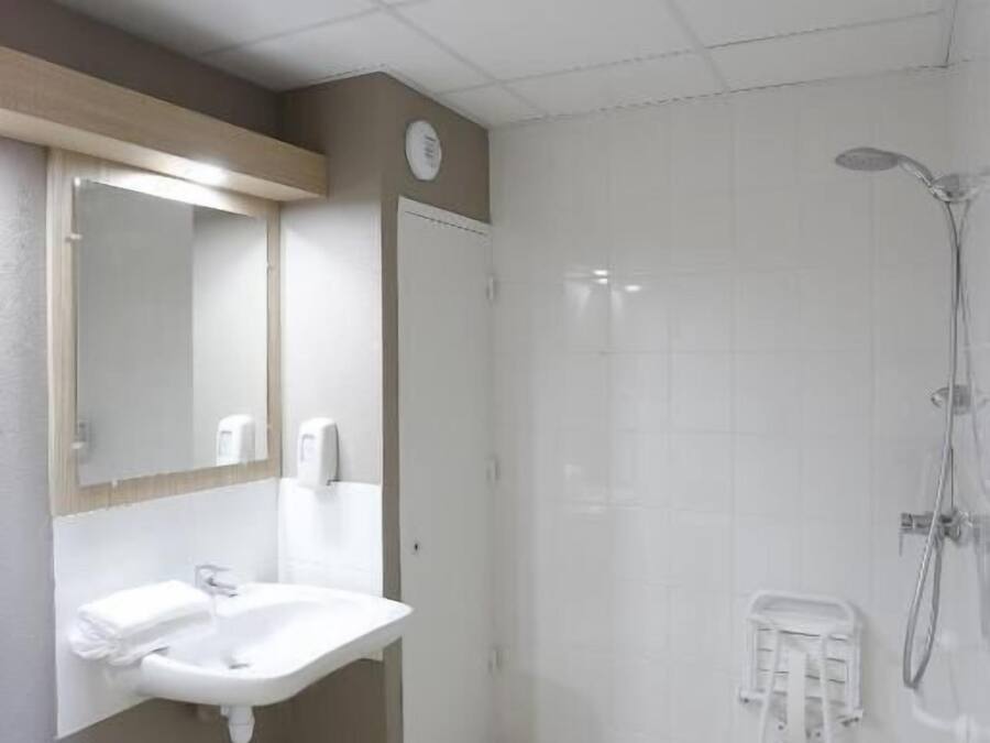 Une salle de bain avec un lavabo, un miroir et une douche.