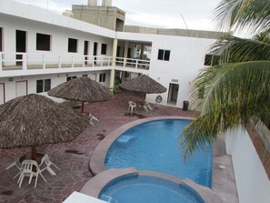 Una piscina al aire libre, sombrillas, tumbonas