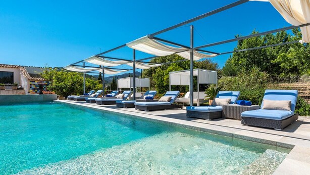A pool area with lounge chairs and umbrellas. -  Finca Son Arnau (Selva)