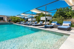 Una piscina al aire libre, tumbonas