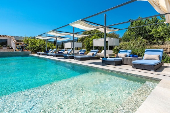 Een buitenzwembad en ligstoelen