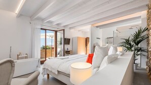A modern bedroom with a bed, bedside table, and a view of the outdoors. -  Finca Son Arnau (Selva)