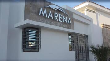 Um edifício com uma placa que diz "MARENA SUITES AND APARTMENTS".