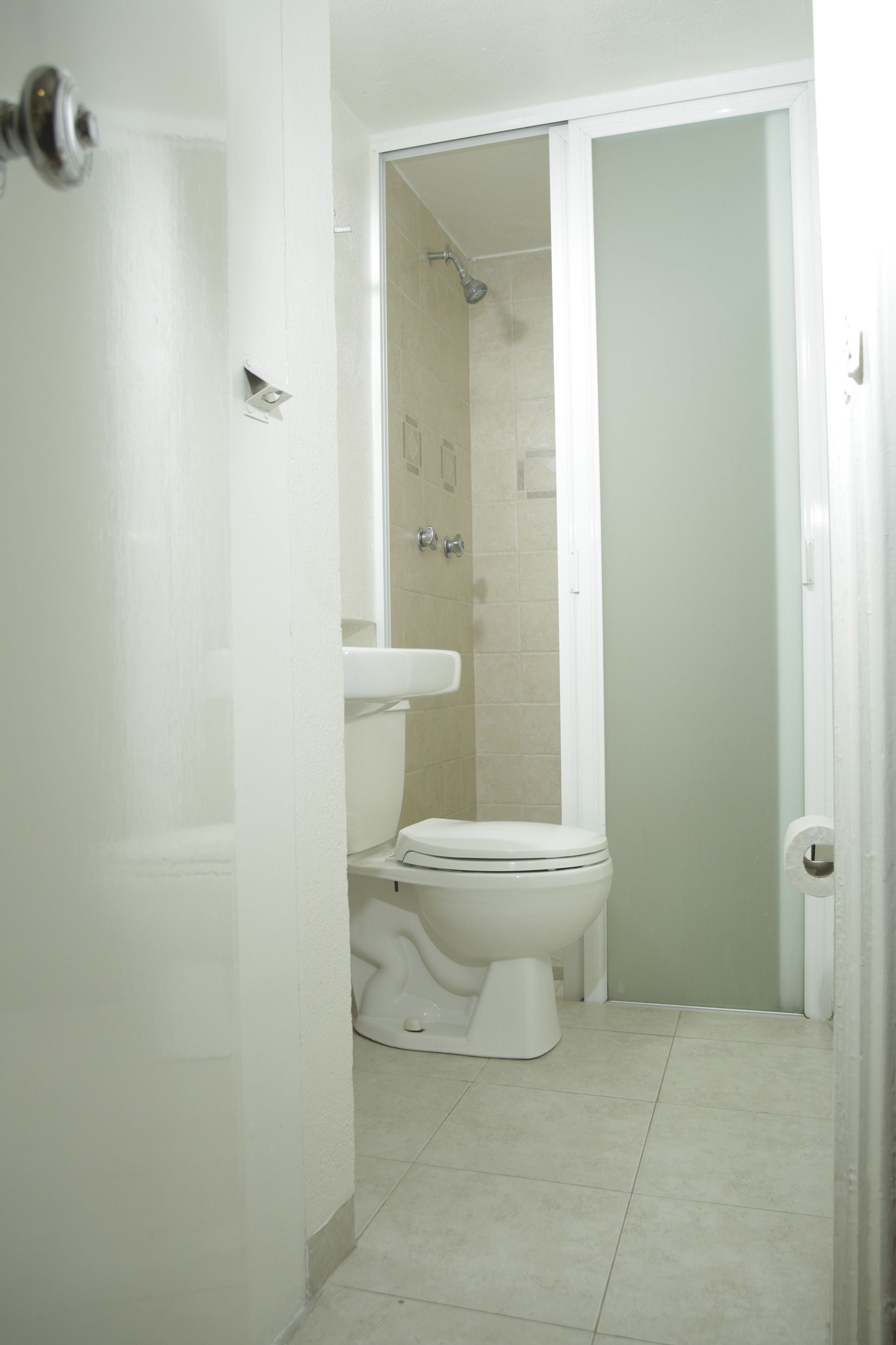 Un baño con inodoro, lavamanos y ducha.