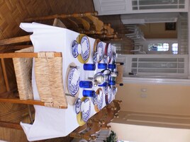 Une table à manger dressée avec de l’argenterie bleue et blanche, des verres bleus et un pichet en argent.