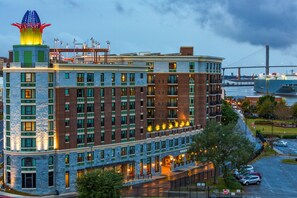 A multi-story hotel with a distinctive tower and a waterfront view.