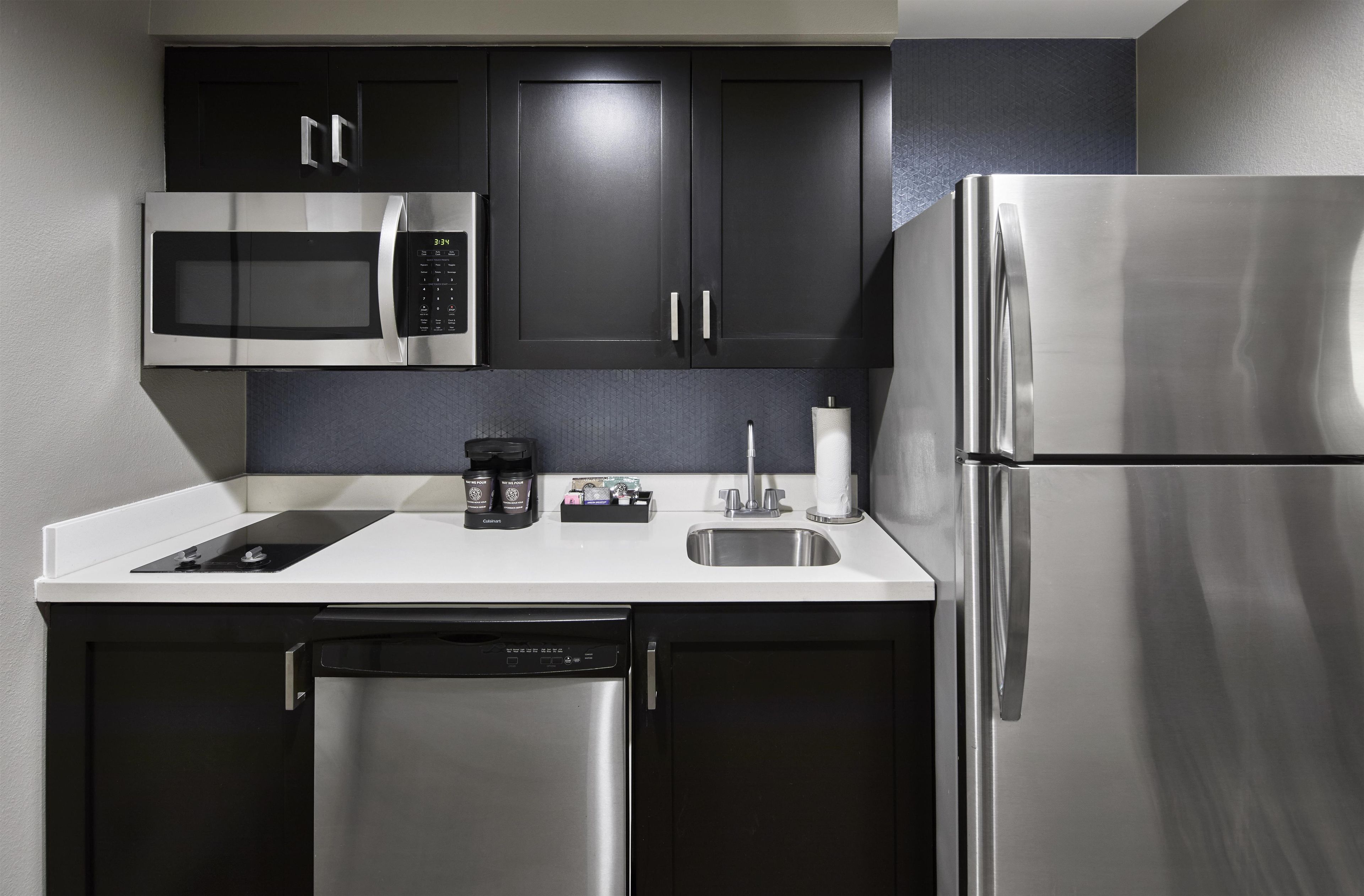 A modern kitchen with a stainless steel refrigerator, a microwave, and a dishwasher.