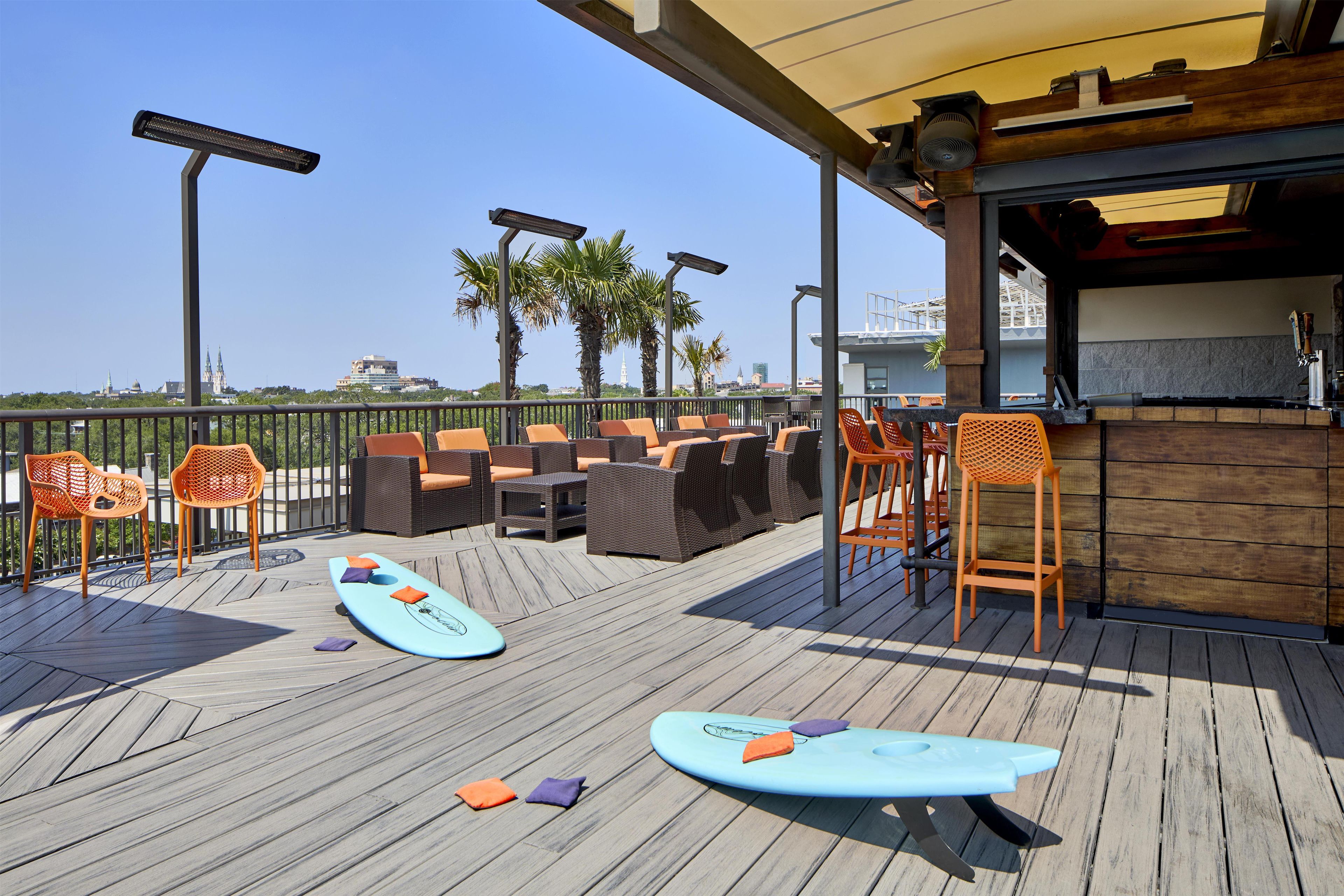 Un espace extérieur aménagé avec des meubles en osier et des planches de surf.