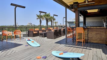 An outdoor seating area with wicker furniture and surfboards.