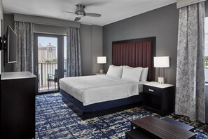 Une chambre d’hôtel avec un lit, deux lampes de chevet, un bureau et un téléviseur.