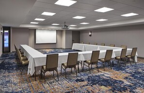 A conference room with a long table, chairs, a projector screen, and a carpeted floor. - Homewood Suites by Hilton Savannah Historic Dist/Riverfront (Savannah)